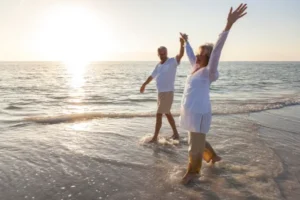 People walking along a Costa del Sol beach in winter sunshine. Non-Lucrative Visa 2026